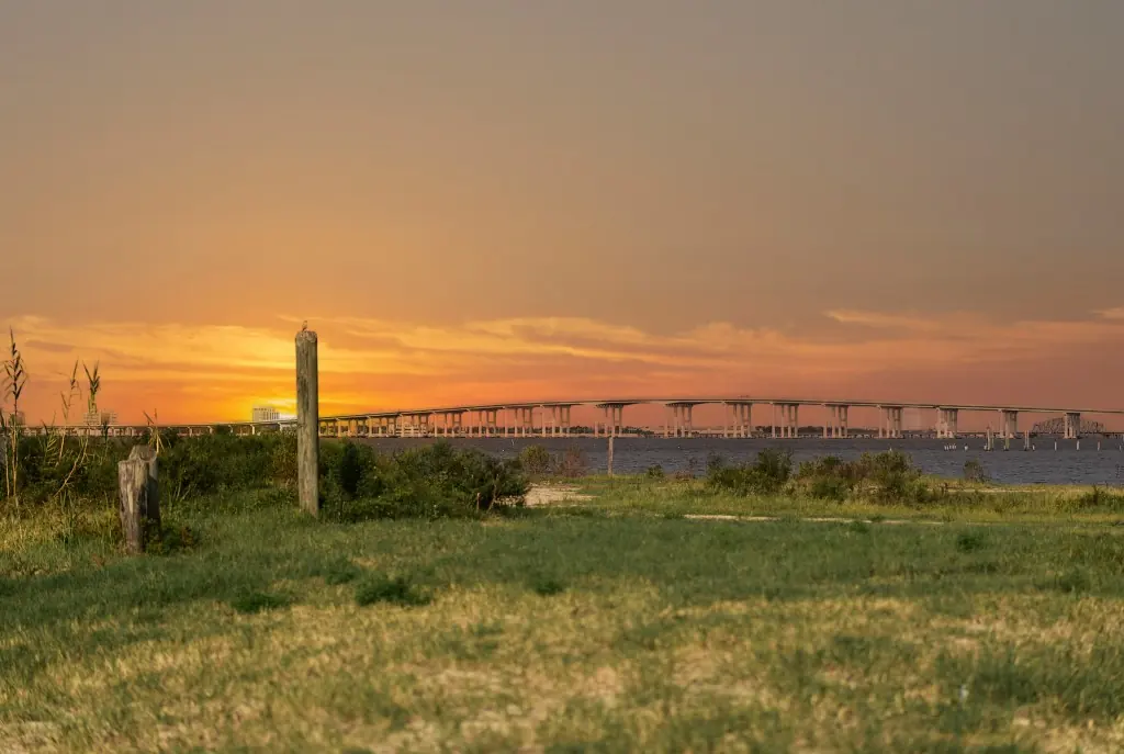Sunset over the Biloxi Bay Bridge from a grassy shoreline on the Mississippi Gulf Coast